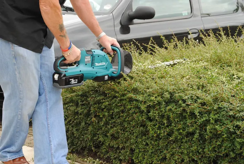 A cordless battery-powered hedge trimmer
