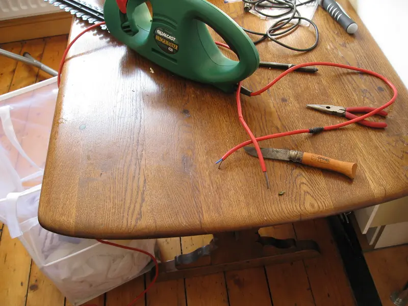 A corded electric hedge trimmer