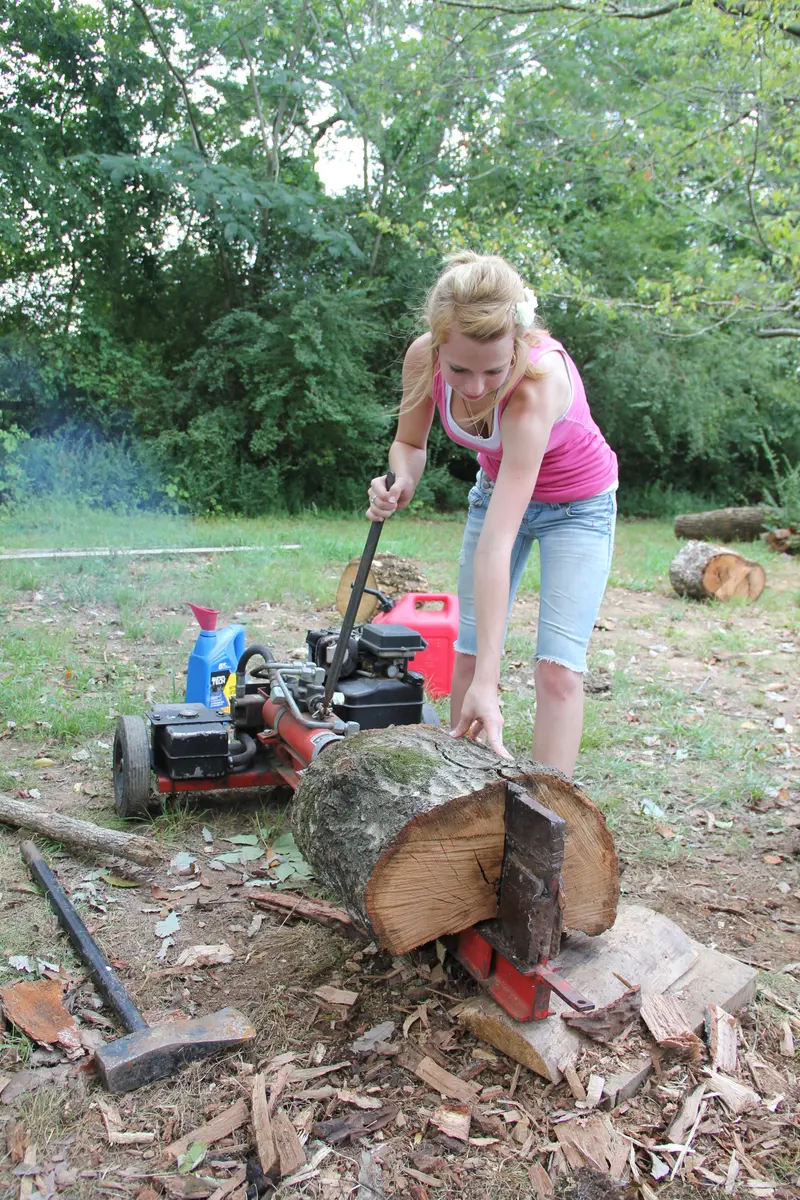 A gas-powered log splitter splitting a round of firewood