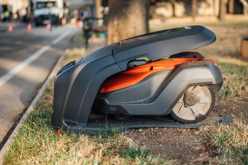 Close-up of a robotic lawn mower moving across cut grass