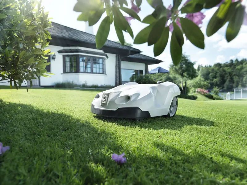 A Husqvarna Automower robotic mower on a green lawn