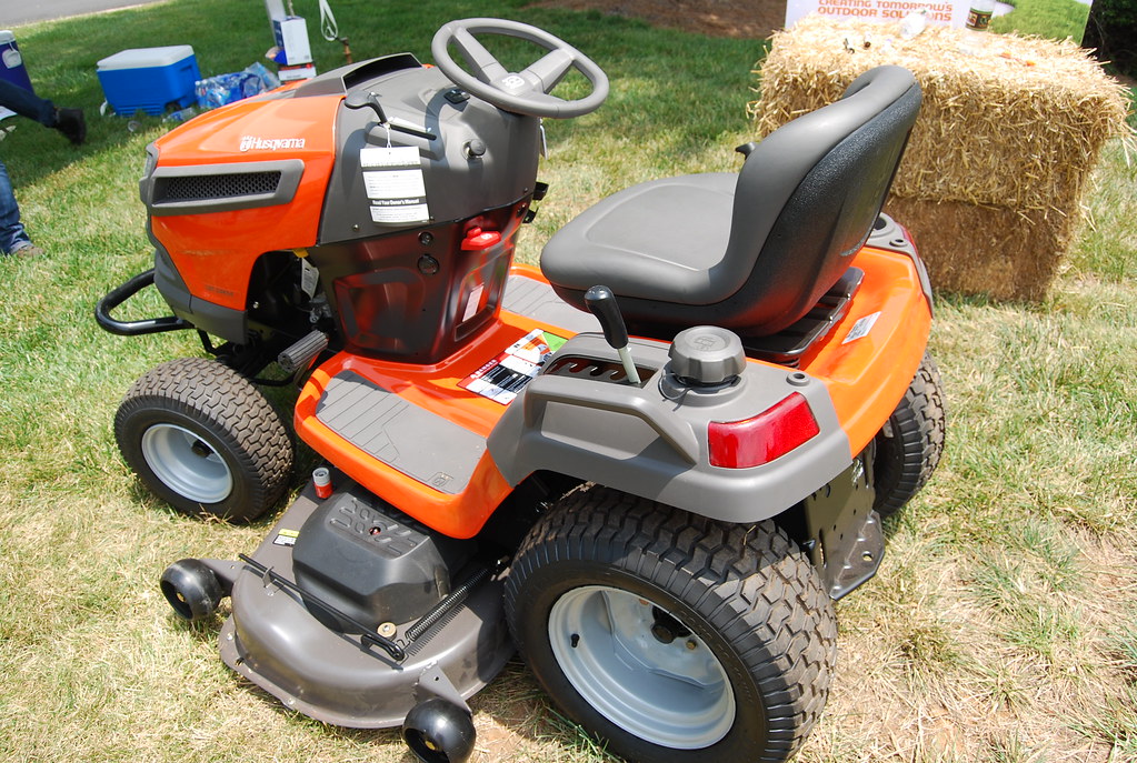 A zero-turn riding mower being demonstrated on a green lawn